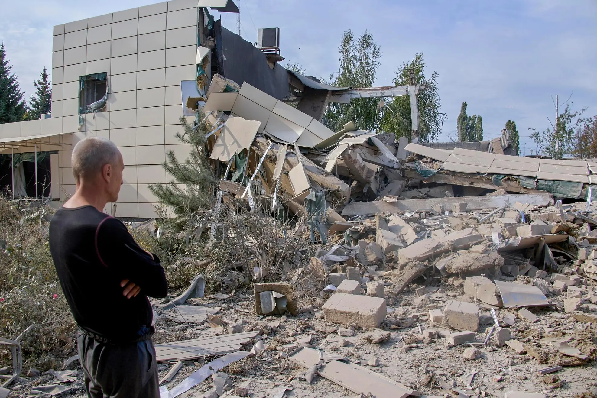 epa10139808 A local man looks at the debris of a college at the site of the shelling in the small city of Derhachi not far from Kharkiv, Ukraine, 26 August 2022 amid Russia's military invasion. At least one civilian person was killed and one injured during the attack, the National police said. Kharkiv and surrounding areas have been the target of heavy shelling since February 2022, when Russian troops entered Ukraine starting a conflict that has provoked destruction and a humanitarian crisis. EPA/SERGEY KOZLOV