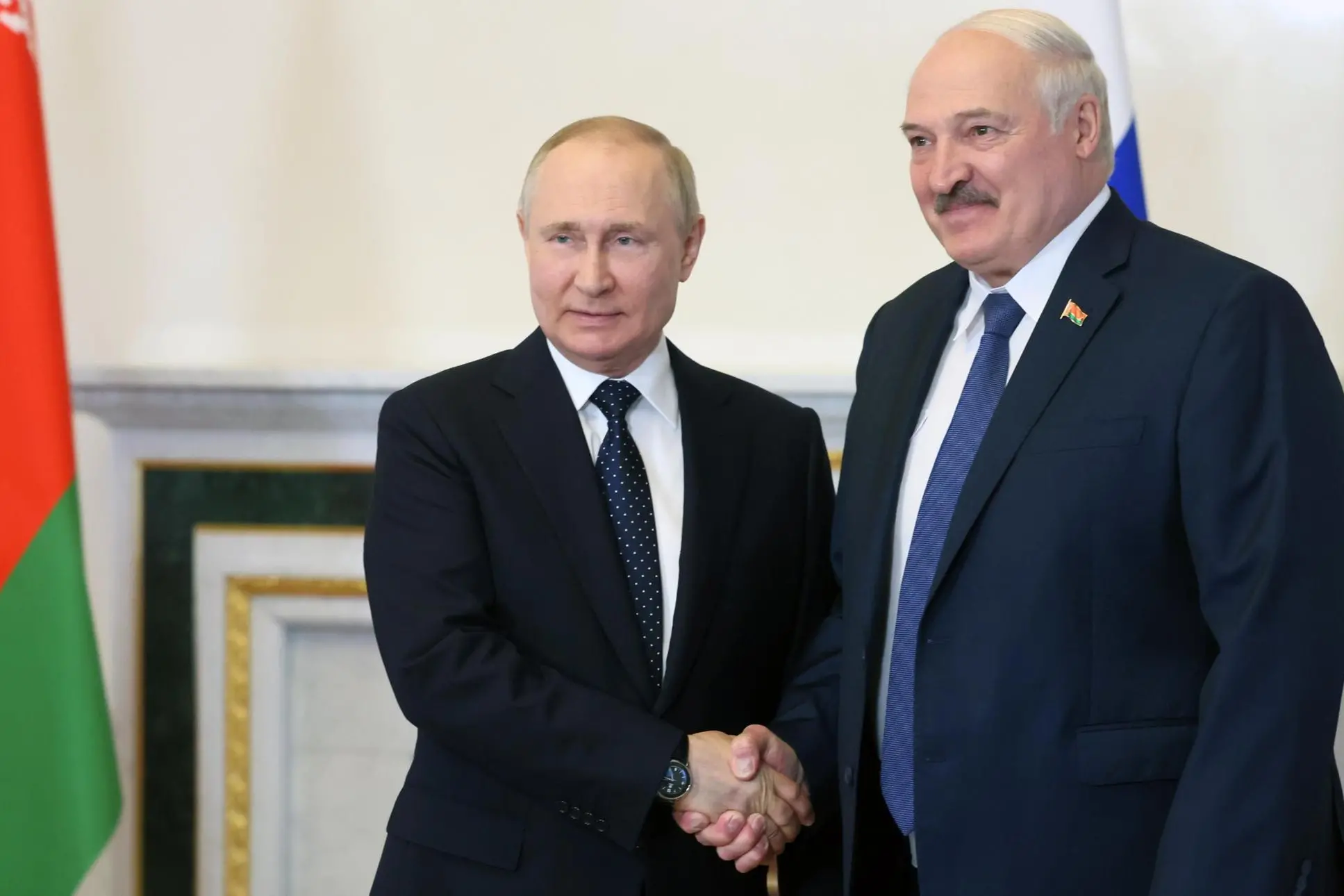 epa10033630 Russian President Vladimir Putin (L) shakes hands with Belarusian President Alexander Lukashenko during their meeting in the Konstantinovsky Palace in St.Petersburg, Russia, 25 June 2022. The meeting is taking place on the day of the 30th anniversary of the establishment of diplomatic relations between the two countries. During the conversation, Alexander Lukashenko asked Vladimir Putin to help adapt Belarusian aircraft to be equipped with nuclear warheads. Vladimir Putin said that Russia would hand over the Iskander-M complexes to Minsk in the coming months. EPA/MIKHAIL METZEL / KREMLIN / POOL MANDATORY CREDIT
