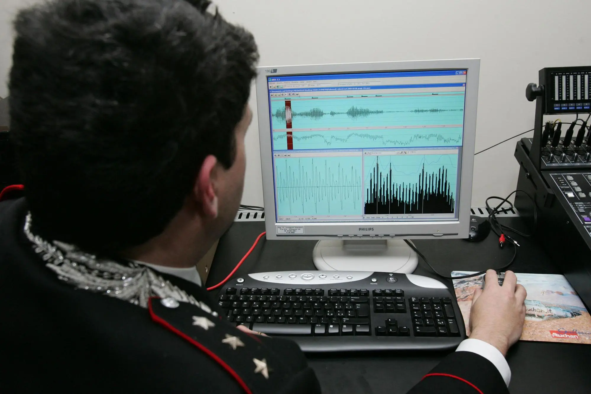 Un carabiniere analizza una traccia audio in una foto di archivio. ANSA / ALESSANDRO DI MEO (intercettazioni, polizia, generica, simbolica, intercettazione, cavo, cavi, telefoni, telefono, telefonino, telefonini, cellulare, cellulari)
