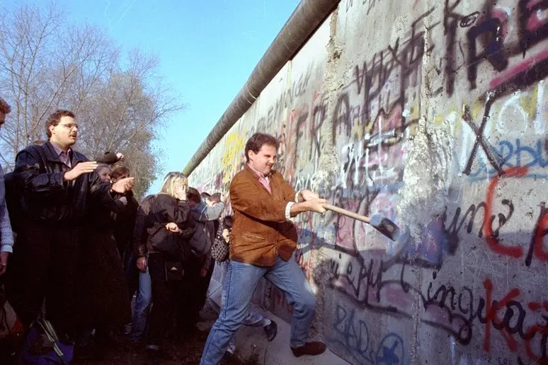 Berlinesi armati di piccone per abbattere il Muro (Ansa)