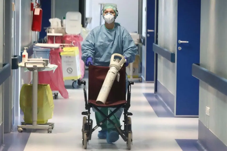 Un'infermiera trasporta una bombola d'ossigeno (Ansa - Venezia)