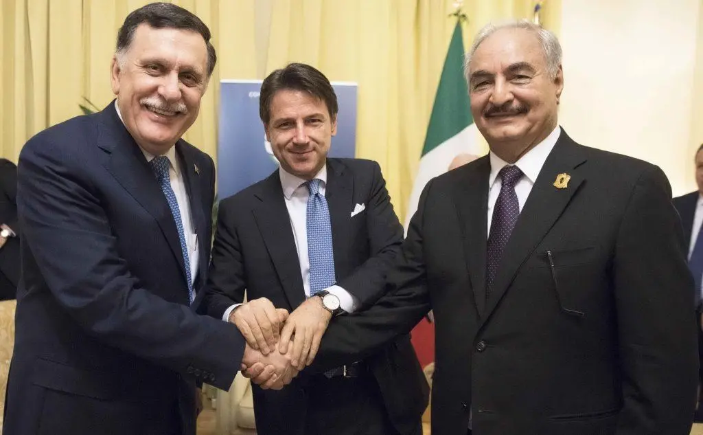 La stretta di mano Haftar-Serraj (Ansa)
