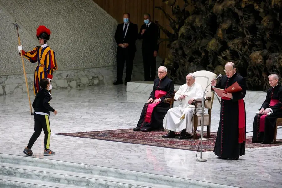 Il bambino si avvicina a Papa Francesco durante l'udienza generale (foto Ansa)