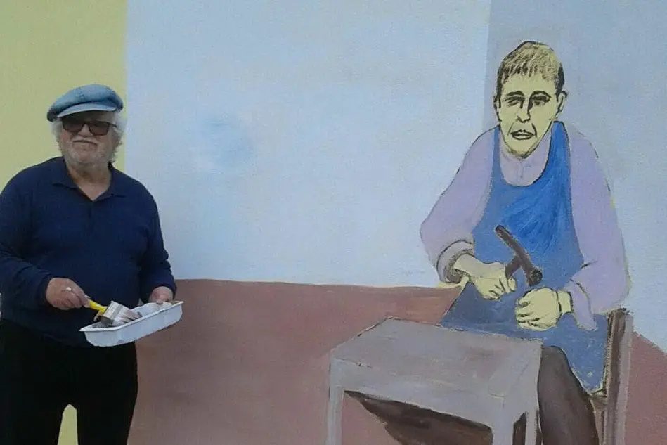 Jelmo Cara posa davanti a un suo murales