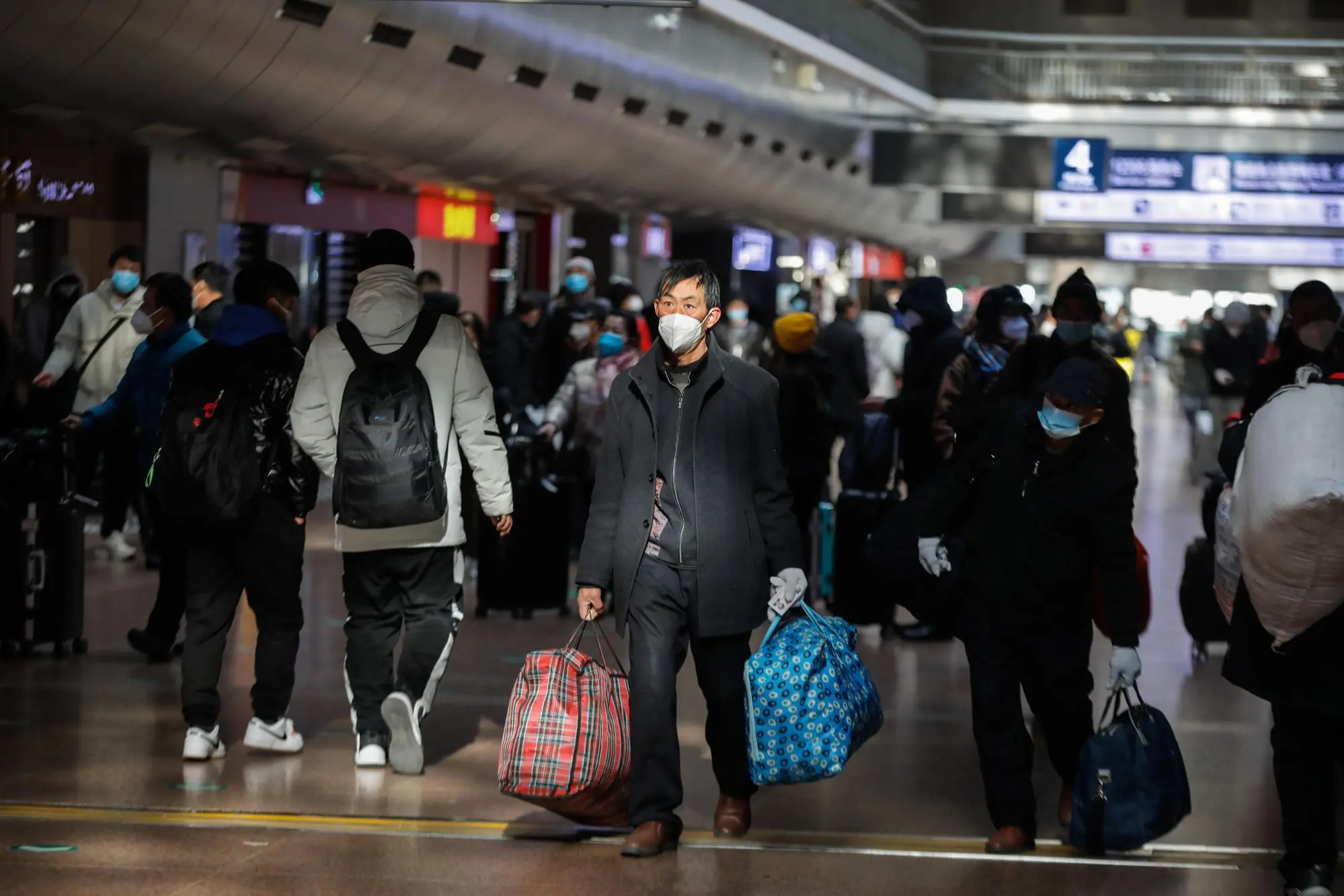 epaselect epa10366640 Passengers wearing face masks walk in Beijing West Railway Station in Beijing, China, 15 December 2022. According to the notice issued by the Beijing Municipal Bureau of Culture and Tourism on 13 December 2022, travel agencies and online travel platforms are allowed to resume inter-provincial group tours in and out of Beijing, and provide packaged services for ticket purchasing and hotel booking. EPA/WU HAO