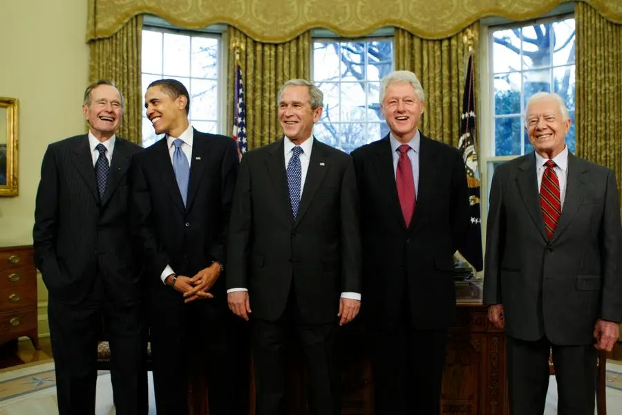Nell'iconico scatto con altri quattro presidenti: Barack Obama, George Bush senior, George Bush junior e Jimmy Carter (Ansa)