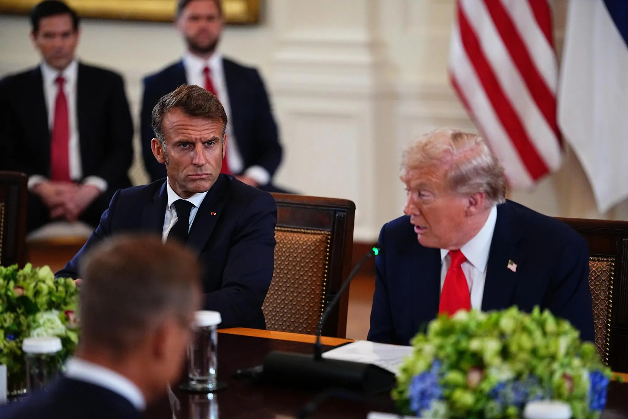 epa12308678 French President Emmanuel Macron (L) listens as United States President Donald J Trump makes remarks as they participate in a Multilateral Meeting with European Leaders in the East Room of the White House in Washington, DC, USA, 18 August 2025. European Leaders are at the White House in support of President Zelenskyy following President Trump