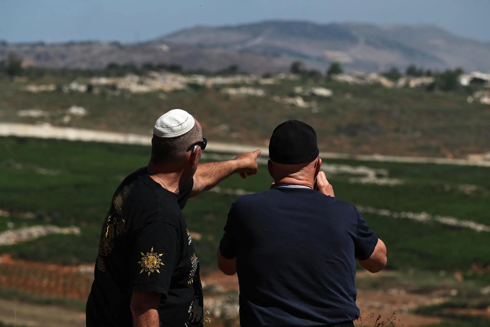 epa13049471 Israeli men look at Lebanese side of the border from the Israeli side of the border in the Upper Galilee, northern Israel, 19 June 2026. The Israel Defense Forces (IDF) carried out multiple airstrikes targeting infrastructure sites across southern Lebanon overnight following what it described as repeated ceasefire violations by Hezbollah, according to an IDF spokesperson. EPA/ATEF SAFADI