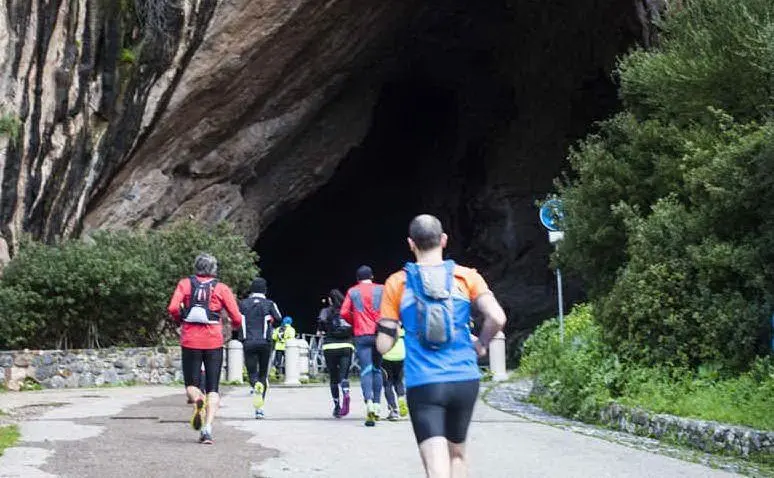 Un passaggio dei runners attraverso la suggestiva grotta di san Giovanni nelle edizioni scorse del Trail del Marganai (foto Simone Farris)