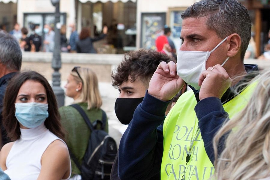 Un agente della Polizia di Roma Capitale invita le persone ad indossare la mascherina a Fontana di Trevi, Roma, 2 ottobre 2020. MAURIZIO BRAMBATTI/ANSA