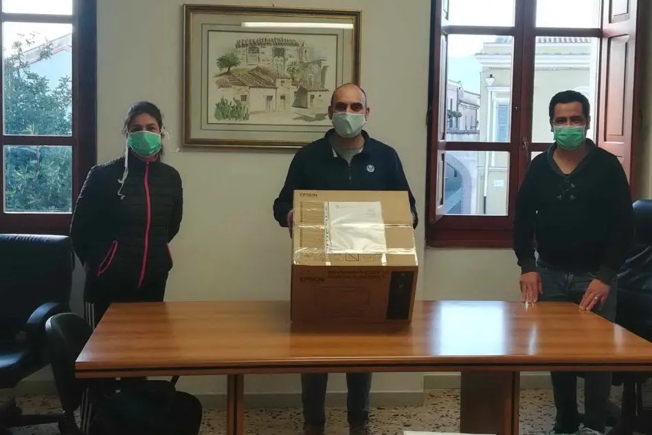 L'assessore Marco Mandis regge il plico di mascherine. Ai lati gli assessori Arianna Porcu e Francesco Mameli (Farris)