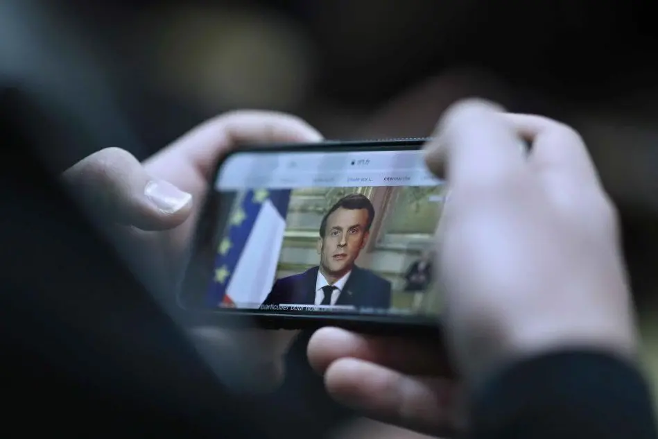 Il discorso di Macron visto da un telefonino (Ansa)