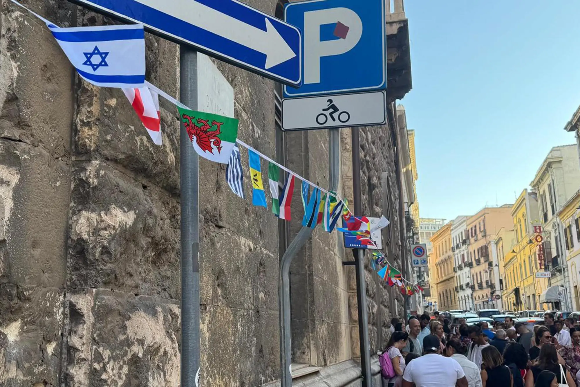 Le bandierine di diversi Paesi appese all’esterno della scuola multietnica di Cagliari durante il primo giorno di scuola (Ansa)