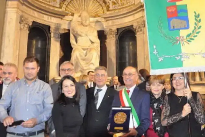 Il sindaco di Tula Gesuino Satta col premio e il gonfalone del paese (foto concessa dall'Amministrazione Comunale)