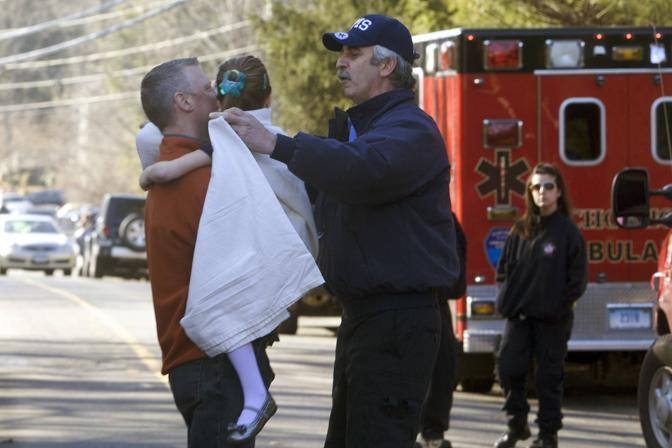 Una bimba portata in salva dalla scuola, dopo l'assalto del 2012 (Archivio L'Unione Sarda)