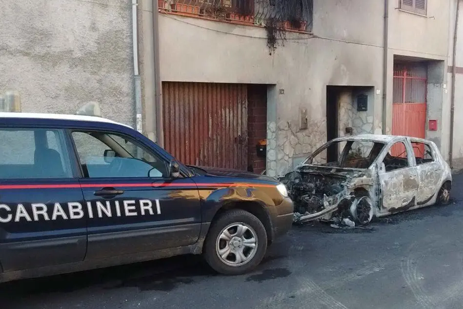 Un'auto dei carabinieri davanti alla Clio data alle fiamme