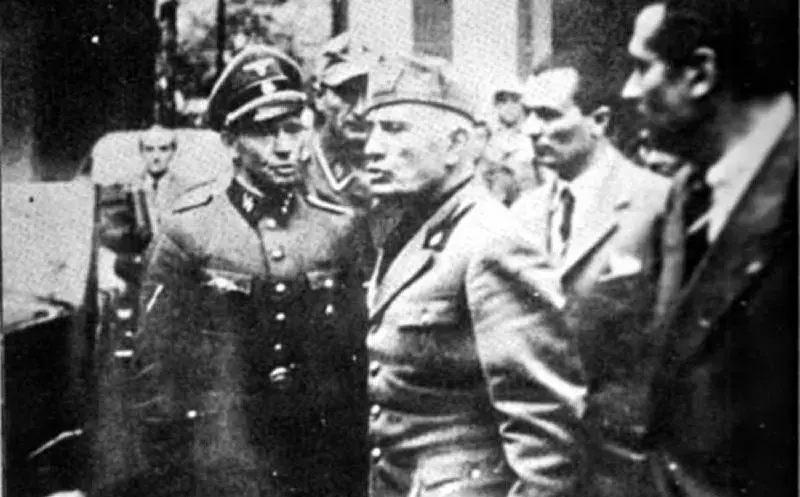 L'uiltima foto che lo ritrae da vivo, mentre lascia la Questura di Milano con un capo scorta delle SS