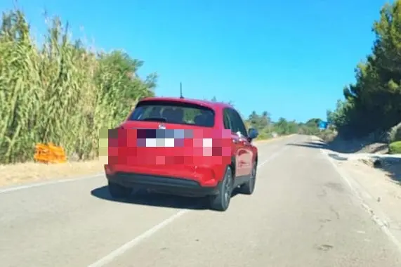 L’auto ripresa da un cittadino mentre il conducente abbandonava rifiuti nell’agro di Porto Torres (foto Pala)