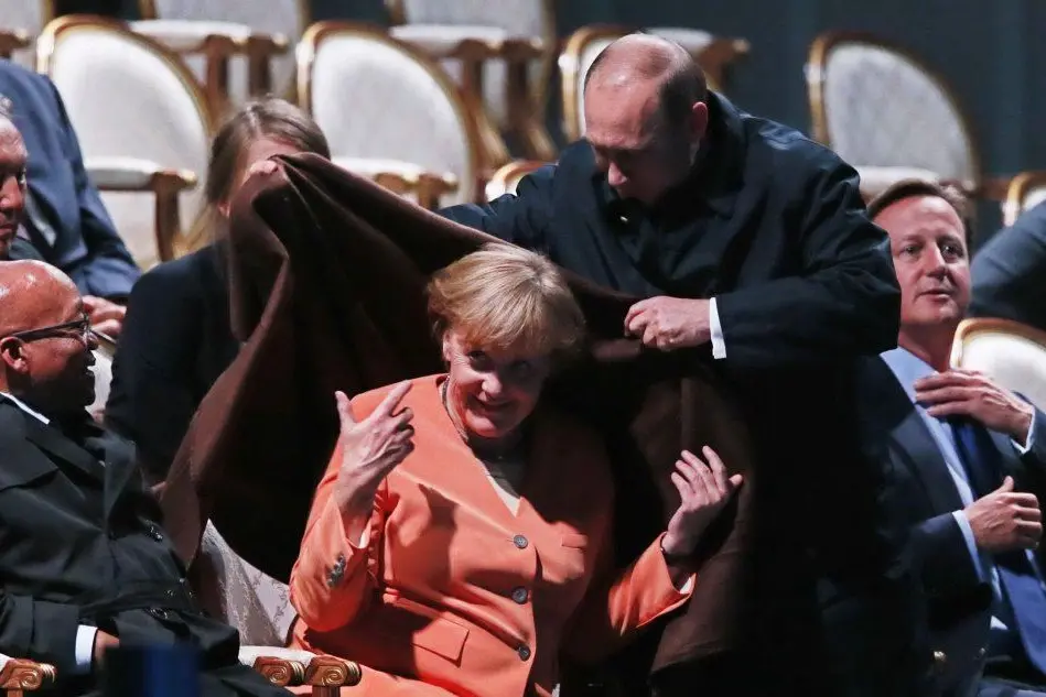 Il presidente russo ripara la Merkel con una coperta