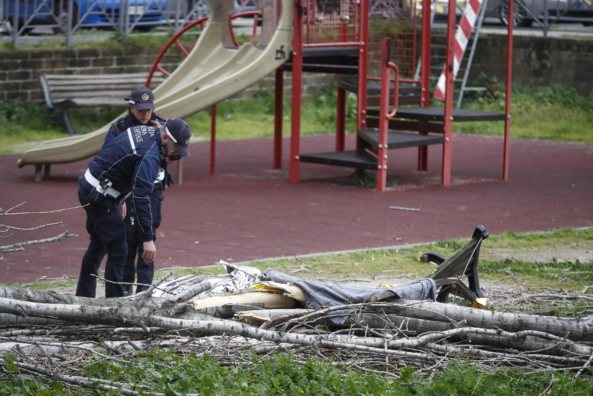 Agenti di Polizia sul luogo in cui una donna è morta, schiacciata da un albero caduto per il forte vento in via Cesare Massimo (Ansa)