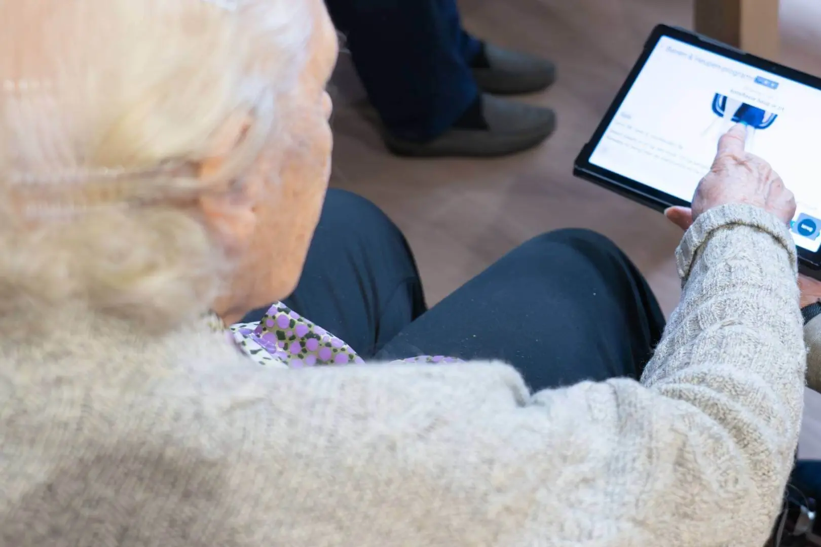 Anziana viene assistita nella procedura di accesso a un servizio online