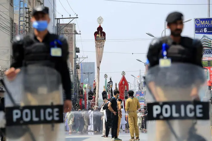 epa09418912 Police officers stand guard along the route of a Muharram mourning process during Ashura Day in Peshawar, Pakistan, 18 August 2021. Shiite Muslims are observing the holy month of Muharram, the climax of which is the Ashura festival that commemorates the martyrdom of Imam Hussein, a grandson of the Prophet Mohammed, in the Iraqi city of Karbala in the seventh century. EPA/BILAWAL ARBAB