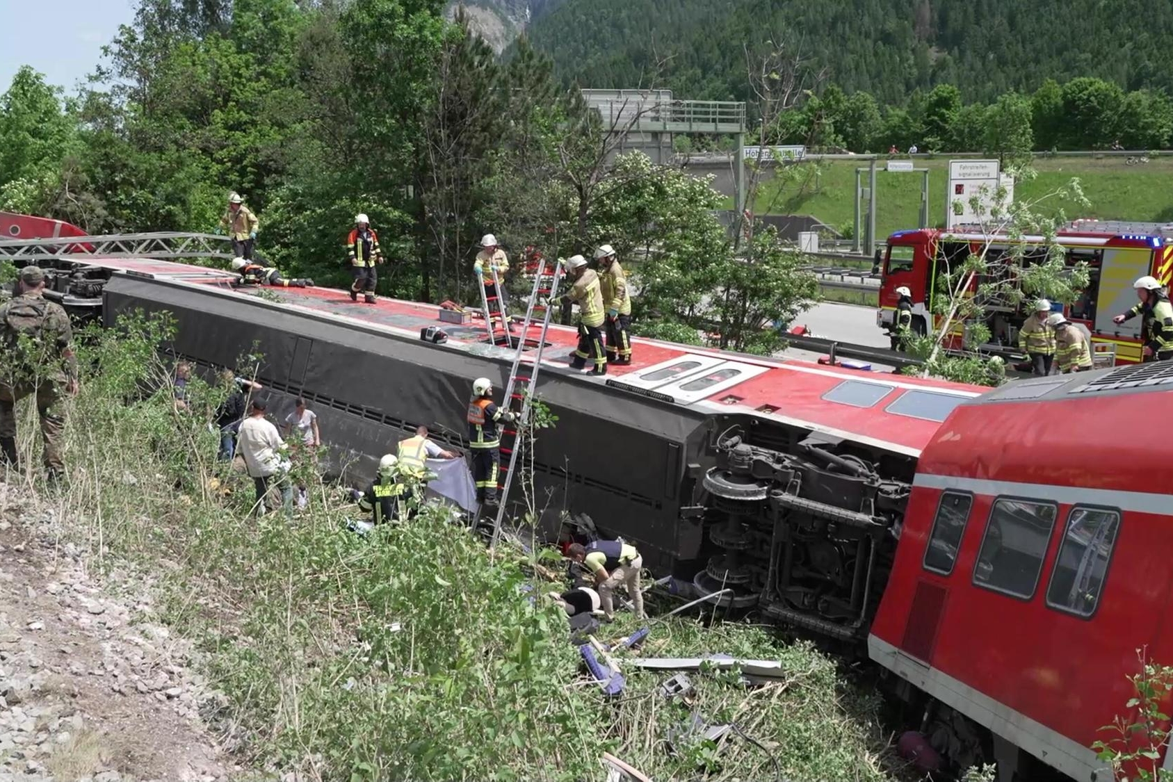 epaselect epa09993745 Emergency responders work at the scene of a train derailment in Burgrain, near the resort town of Garmisch-Partenkirchen, southern Germany, 03 June 2022. According to the police and local officials, at least 3 people are reported dead and dozens were injured in the train derailment. The regional train was heading north from the German Alps towards Munich. EPA/NETWORK PICTURES