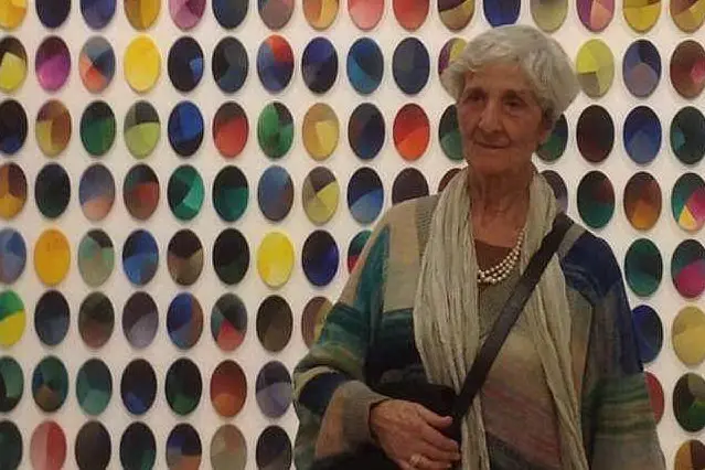 Rosanna Rossi davanti a una delle opere in esposizione alla Galleria comunale d'arte di Cagliari