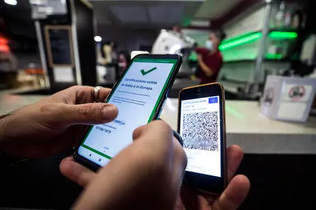 A visitor's Covid-19 Green Pass is checked at the entrance to a bar in Rome, Italy, 09 August 2021. Effective from 06 August, the so-called Green Pass is advocated by the government as the alternative to lockdowns in the light of the spreading Delta variant of the Sars-Cov-2 pandemic coronavirus. People who do not hold the certificate that identifies them as either immunised, recovered or tested for Covid-19 may be excluded from indoor venues and for access to amusement parks it is necessary to be up to date with anti-covid-19 vaccinations, or have a negative swab in the last 48 hours. ANSA/ANGELO CARCONI
