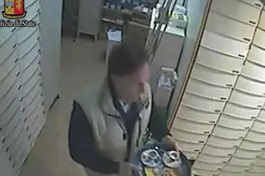 La foto diffusa dalla questura di Milano di Gianfranco Bona, 50 anni, mentre porta un analcolico e un caffé dal bar fino alla farmacia dell'amico, Luigi Fontana