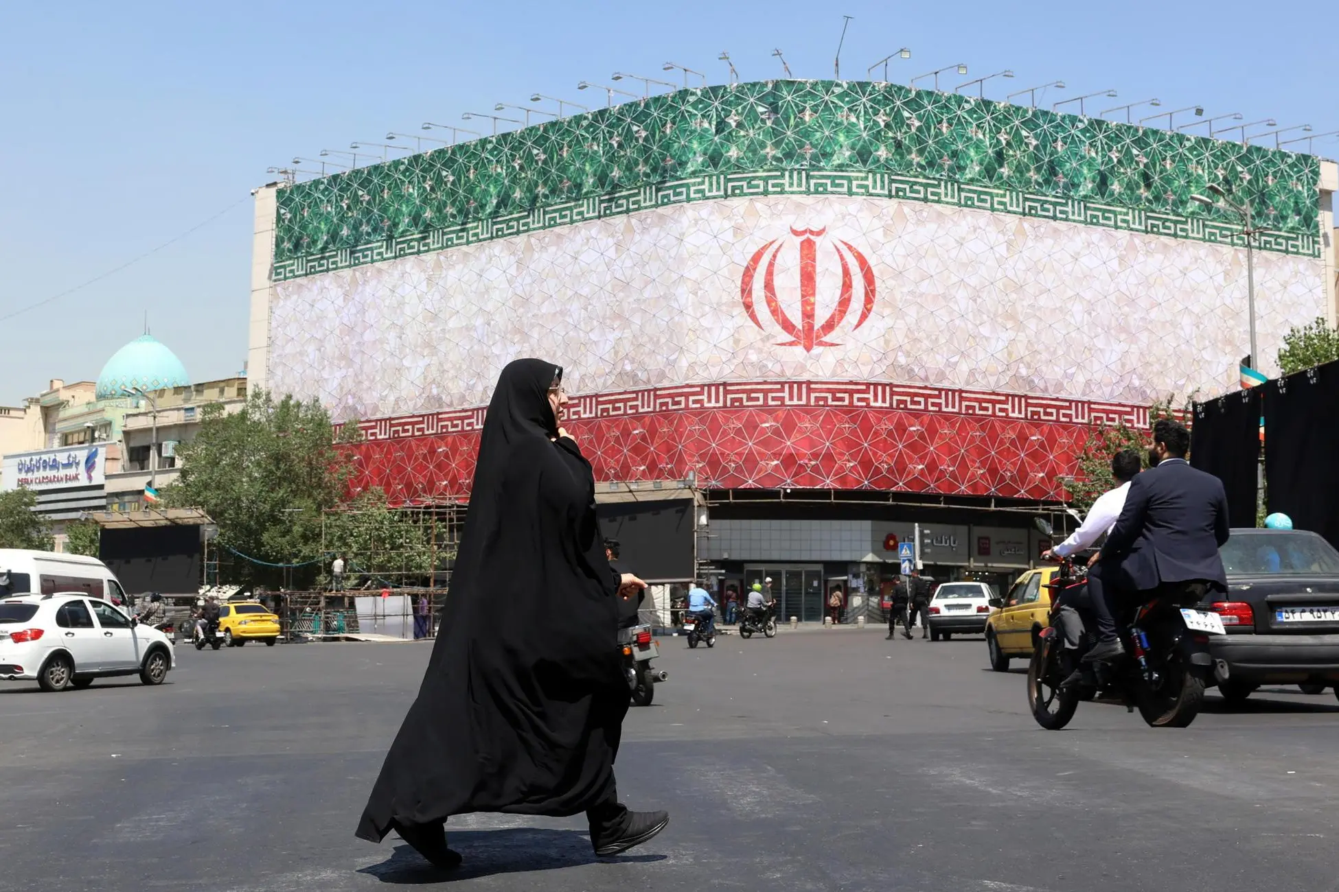 «Rinuncia all’atomica e riapertura di Hormuz»: le condizioni dell’intesa Usa-Iran epa13035939 A veiled Iranian woman walks past a billboard featuring Iran's national flag at Enqelab Square in Tehran, Iran, 14 June 2026. US President Donald Trump saying on a social media platform that a deal could be signed soon. EPA/ABEDIN TAHERKENAREH RESTRICTIONS: NO Access Israel Media/Persian Language TV Stations Outside Iran/Strictly No Access BBC Persian/VOA Persian/Manoto TV/Iran International TV. (As mandated by Iran's Directorate General for Foreign Media) --