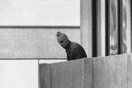 FILE - In this Sept. 5, 1972, file photo, a Palestinian gunman looks from an apartment in which were seized members of the Israeli Olympic Team at their quarters at the Munich Olympic Village. (ANSA/AP Photo/Kurt Strumpf, File)