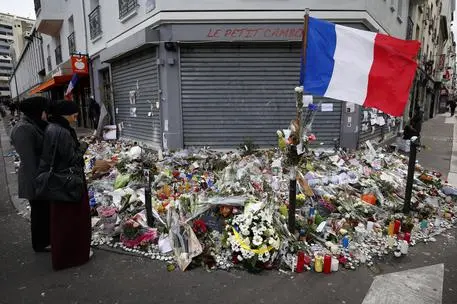 epa05035825 People gather in front of the memorial set near the Le Petit Cambodge restaurant to mark a week since the start of the terrorist attacks, in Paris, France, 21 November 2015. More than 130 people were killed and hundreds injured in the terror attacks which targeted the Bataclan concert hall, the Stade de France national sports stadium, and several restaurants and bars in the French capital on 13 November. EPA/SEBASTIEN NOGIER