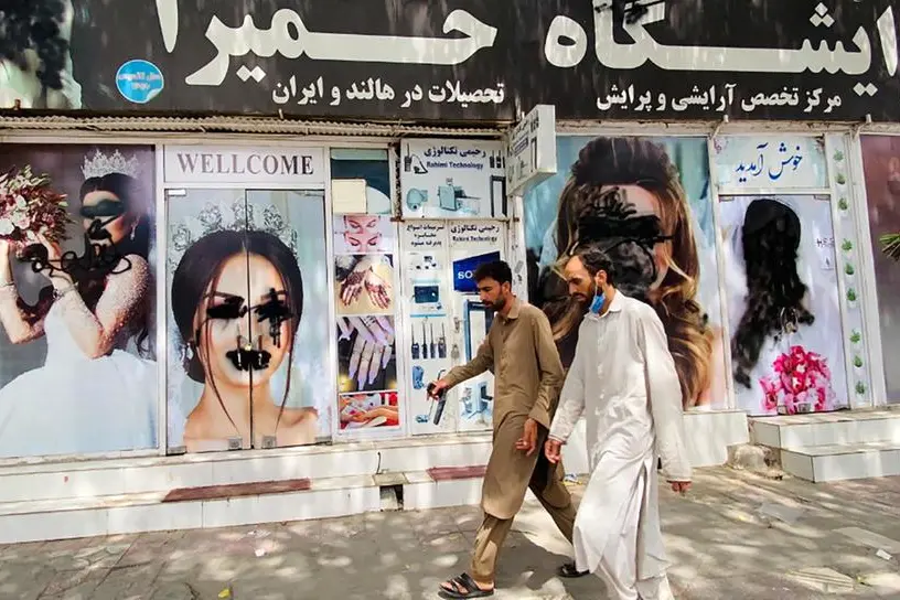 Una strada di Kabul, con manifesti pubblicitari oscurati dal regime (Ansa-Epa)