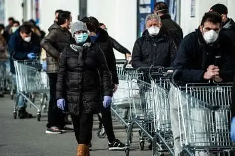 Le lunghe file al supermercato durante il lockdown (Ansa)