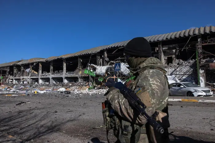 epa09815666 A Ukrainian soldier looks towards Bucha town, which is currently controlled by the Russian military, as he stands guard at the checkpoint at the frontline in Irpin town, Kyiv (Kiev) region, Ukraine, 10 March 2022. Thousands of residents are feeling Irpin and Bucha, as well as other settlements near Kyiv which were the most affected by the Russian army invasion. EPA/ROMAN PILIPEY