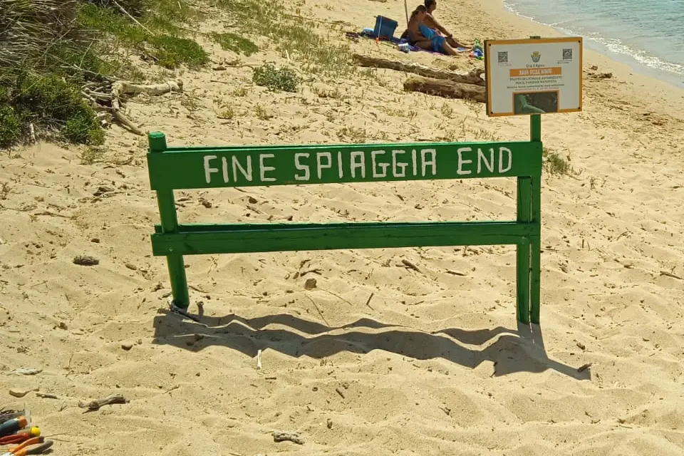 Uno steccato per segnalare il confine dI una spiaggia naturista