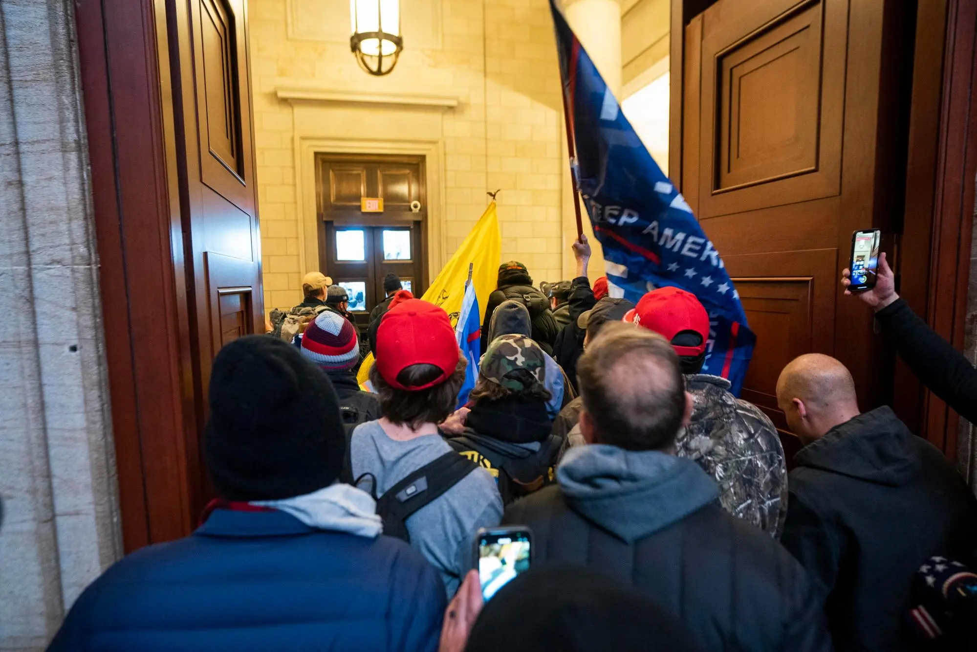 (fILE) - Supporters of US President Trump stand by the door of the Eastern front after they breached the US Capitol security in Washington, DC, USA, 06 January 2021 (reissued 03 January 2021). Following the November 2020 US presidential election, a tone set by supporters of defeated US President Donald Trump escalated further. Trump, who was refusing to concede the victory of Joe Biden, claiming voter fraud and rigged elections, told supporters and white nationalist extreme-right group Proud Boys to respectively 'Stop the Steal' and to 'stand back and stand by'. His social media accounts were suspended and the alt-right platform Parler gained in user numbers. On 06 January 2021, incumbent US vice president Pence was due to certify the Electoral College votes before Congress, the last step in the process before President-elect Biden was to be sworn in. In the morning, pro-Trump protesters had gathered for the so-called Save America March. Soon after Trump finished his speech at the Ellipse, the crowd marched to the Capitol. The attack had begun. Rioters broke into the Capitol building where the joint Congress session was being held. Lawmakers barricaded themselves inside the chambers and donned tear gas masks while rioters vandalized the building, some even occupying offices such as House Speaker Pelosi's. Eventually in the evening the building was cleared from insurrectionists, and the Congress chambers reconvened their session, confirming Joe Biden as the winner of the 2020 US presidential election. In the aftermath, more than 600 people were charged with federal crimes in connection to the insurgency, and close Trump aides such as Steve Bannon, Mark Meadows and Roger Stone were subpoenaed by the House select committee investigating the attack. Trump himself was acquitted by the Senate in his second impeachment trial, this time for "inciting an insurrection". ANSA/JIM LO SCALZO ATTENTION: This Image is part of a PHOTO SET *** Local