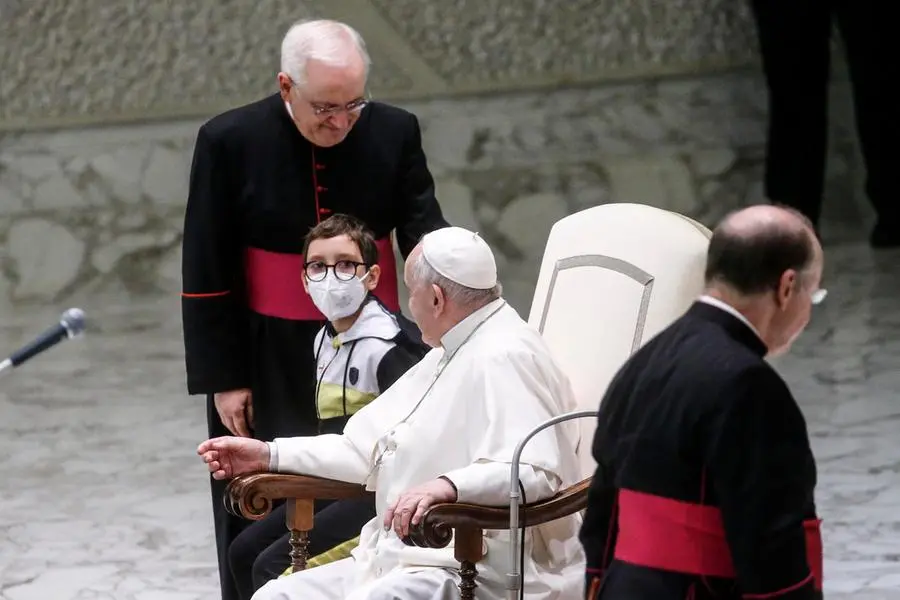 Il bambino seduto accanto al Papa (foto Ansa)
