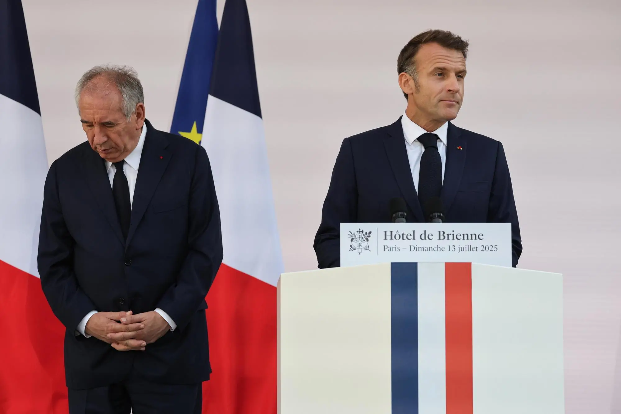 epa12236070 France Prime Minister Francois Bayrou (L) looks on as French President Emmanuel Macron (R) delivers a speech to army leaders on the eve of the annual Bastille Day Parade, at the l