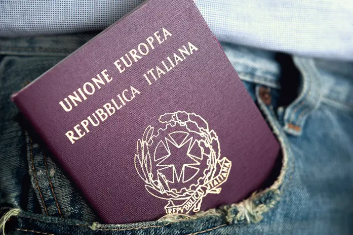 An italian passport out of the pocket of denim trousers