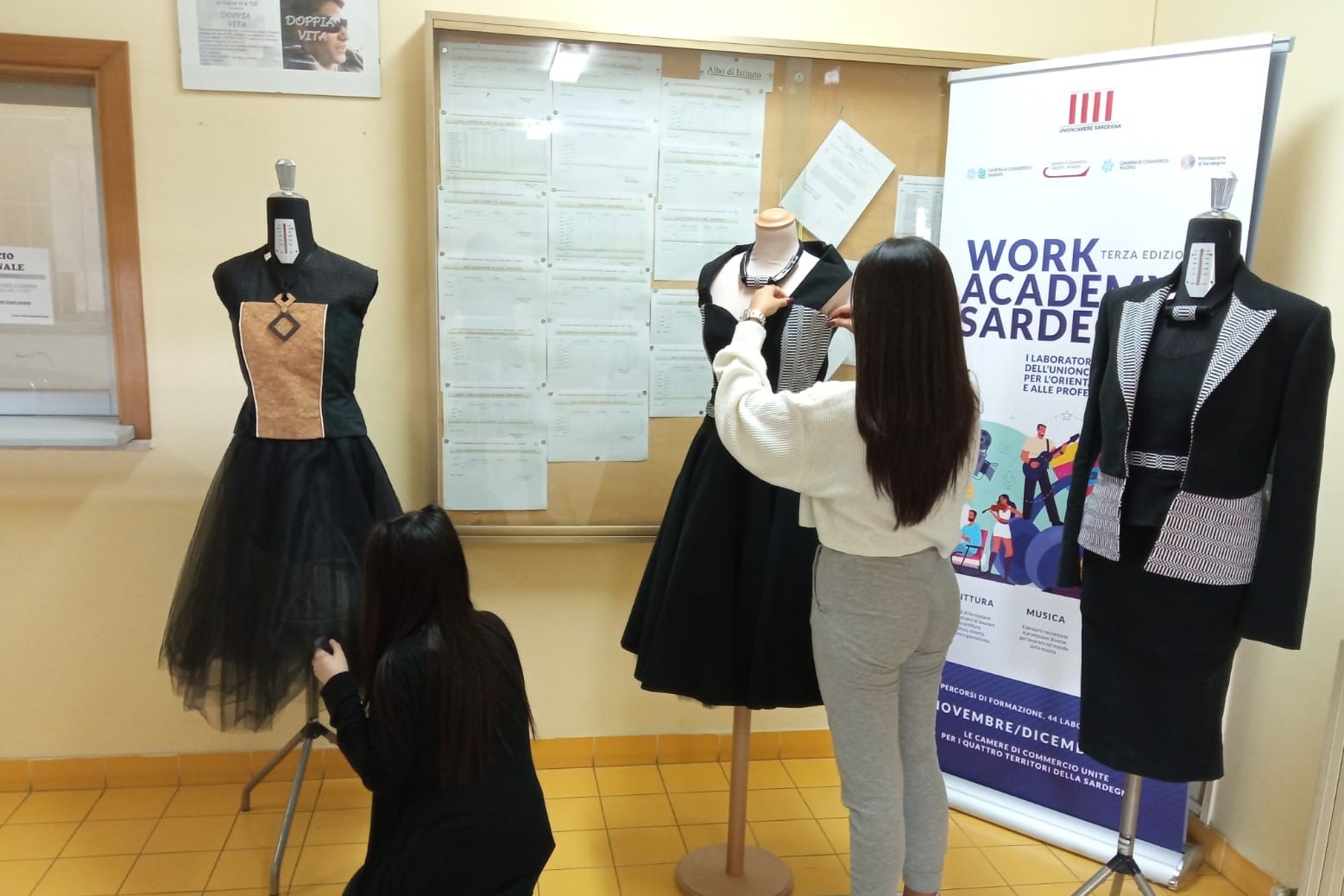 Alcune alunne sistemano gli abiti per l'esposizione (foto Melis)