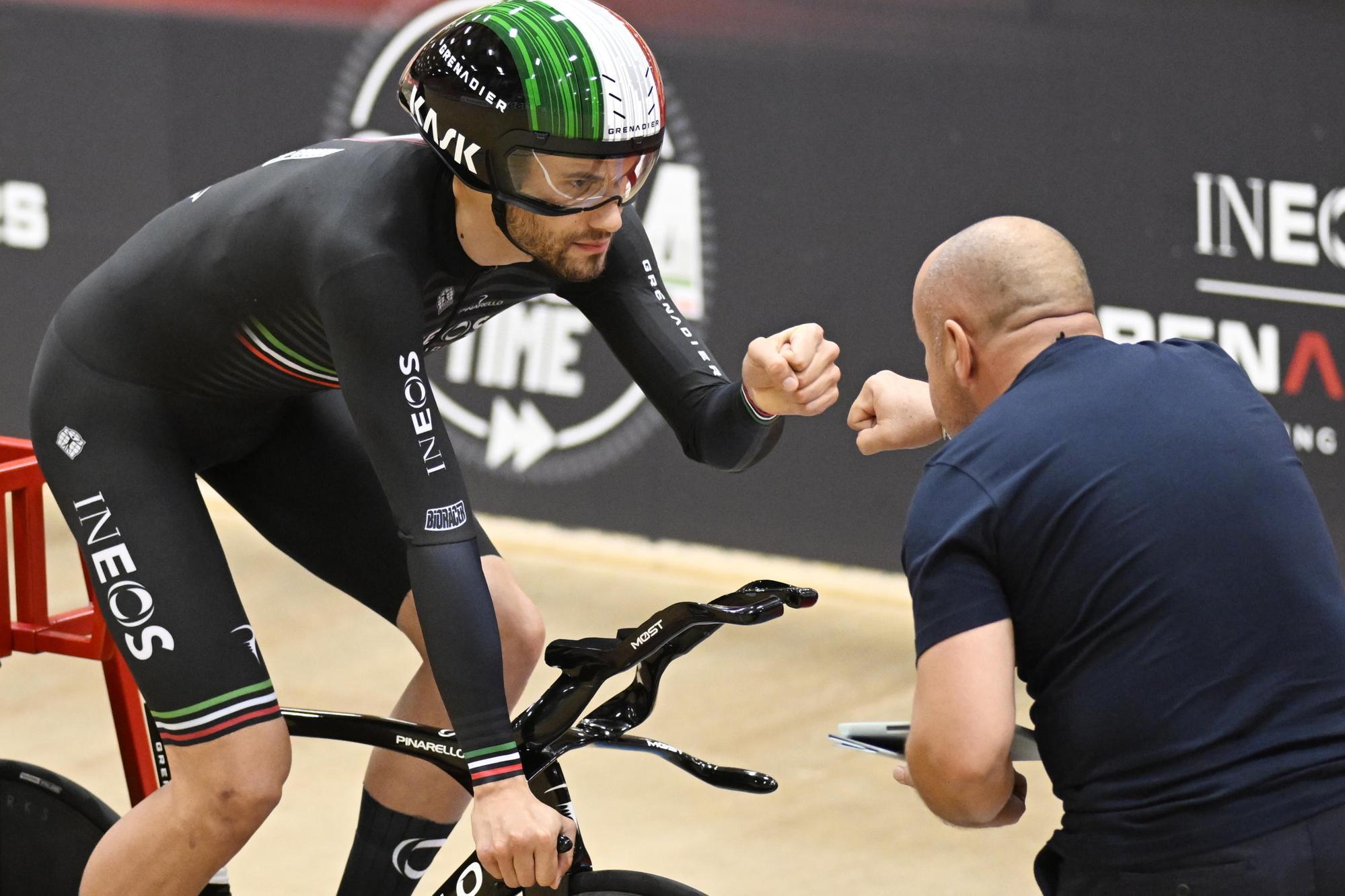 epa10231635 Italian cyclist Filippo Ganna (L) and his coach Marco Villa during his attempt to break the one hour cycling world record at the Velodrome Suisse in Grenchen, Switzerland, 08 October 2022. EPA/MARCEL BIERI