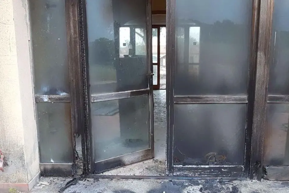 La porta incendiata nel corso del raid vandalico