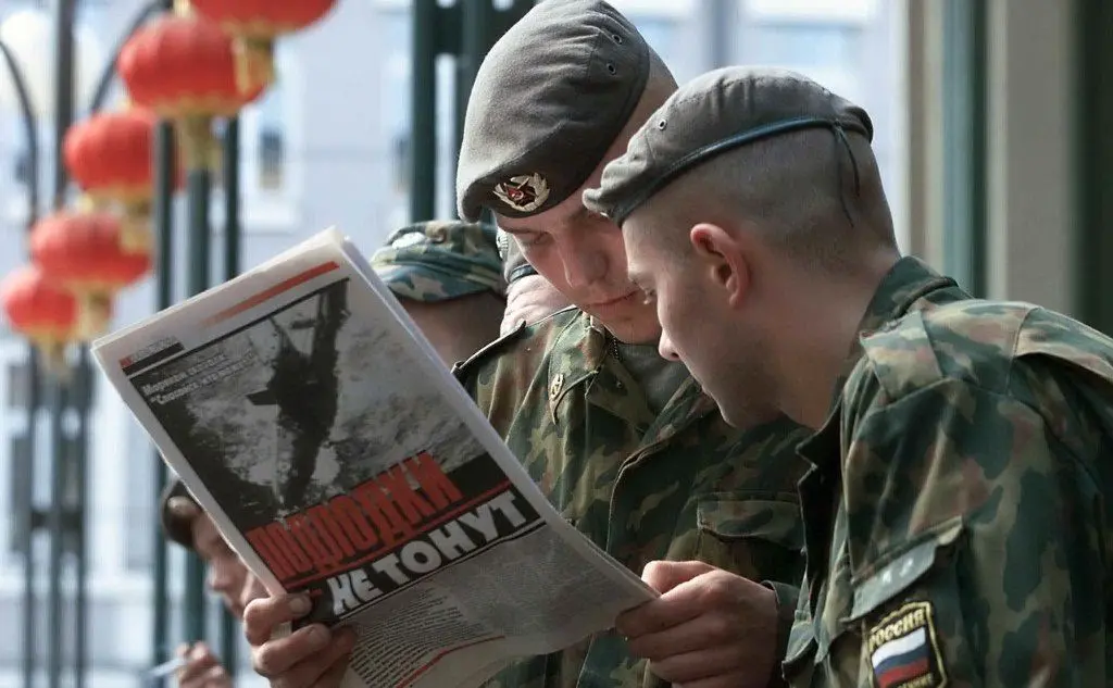 Soldati russi leggono il giornale con la notizia del sottomarino affondato