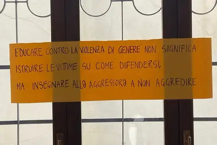 I cartelli di protesta contro l'opuscolo (Ansa)