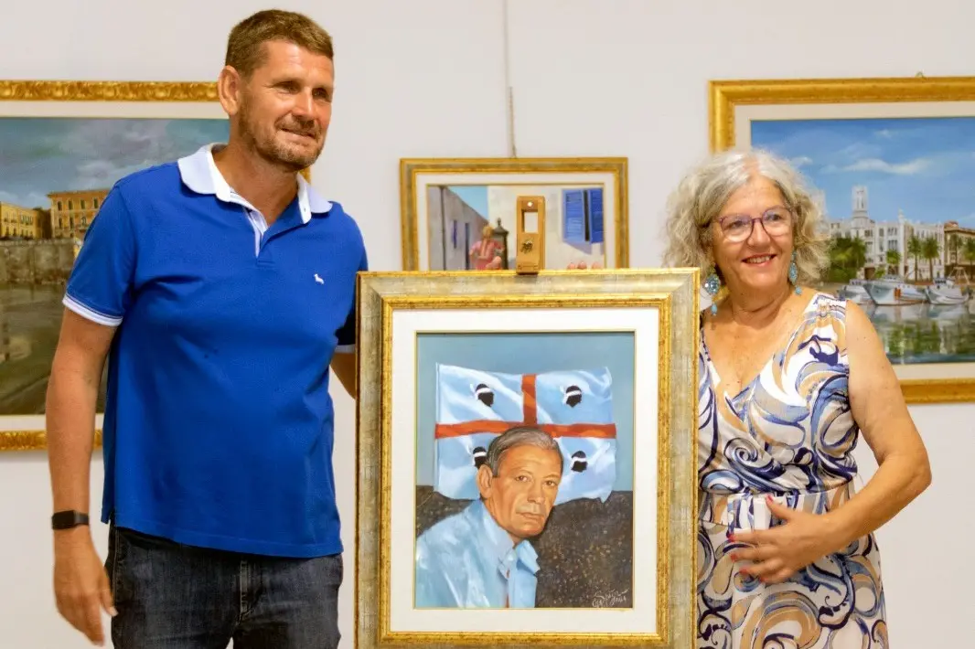 Nicola Riva e Maria Grazia Spiga con il quadro "Dedicato a te, Rombo di Tuono"