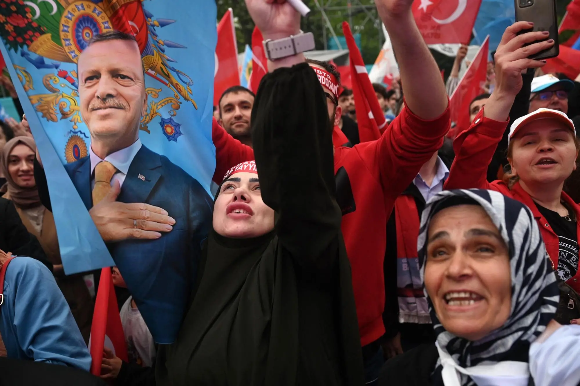 Supporters of Turkish President wave a flag depicting Recep Tayyip Erdogan in front of AK Party’s headquarter in Istanbul on the day of the Presidential runoff vote in Istanbul, on May 28, 2023. (Photo by OZAN KOSE / AFP)