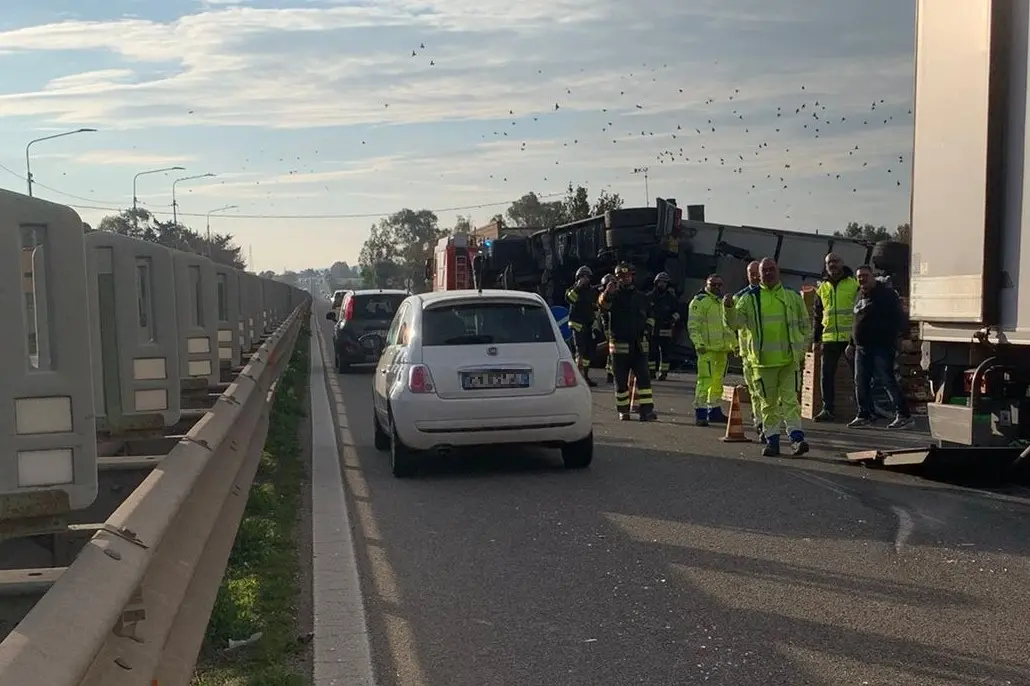 Il tir ribaltato sulla 131 a Villagreca e le operazioni di rimozione (foto Pillosu)