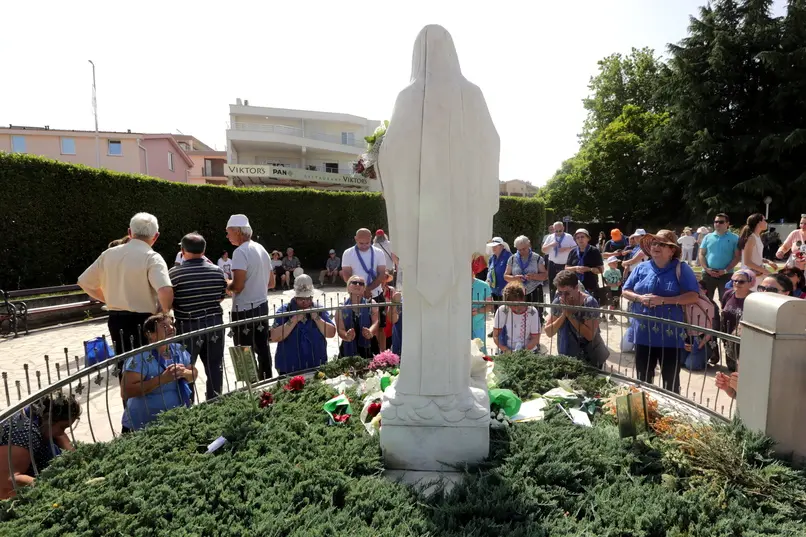 epa09300784 Pilgrims pray at the statue of Our Lady of Medjugorje near the church in the village of Medjugorje, Bosnia and Herzegovina, 25 June 2021. Pilgrims gathered in Medjugorje to mark the 40th anniversary of the alleged appearance of the Virgin Mary to local shepherds in the hills surrounding the village. More than 30 million people are believed to have visited the world-famous village since the saint's first appearance. The Catholic Church has not yet recognized the miracle of Holy Mary's appearance to the Medjugorje shepherds on 24 June 1981. EPA/FEHIM DEMIR